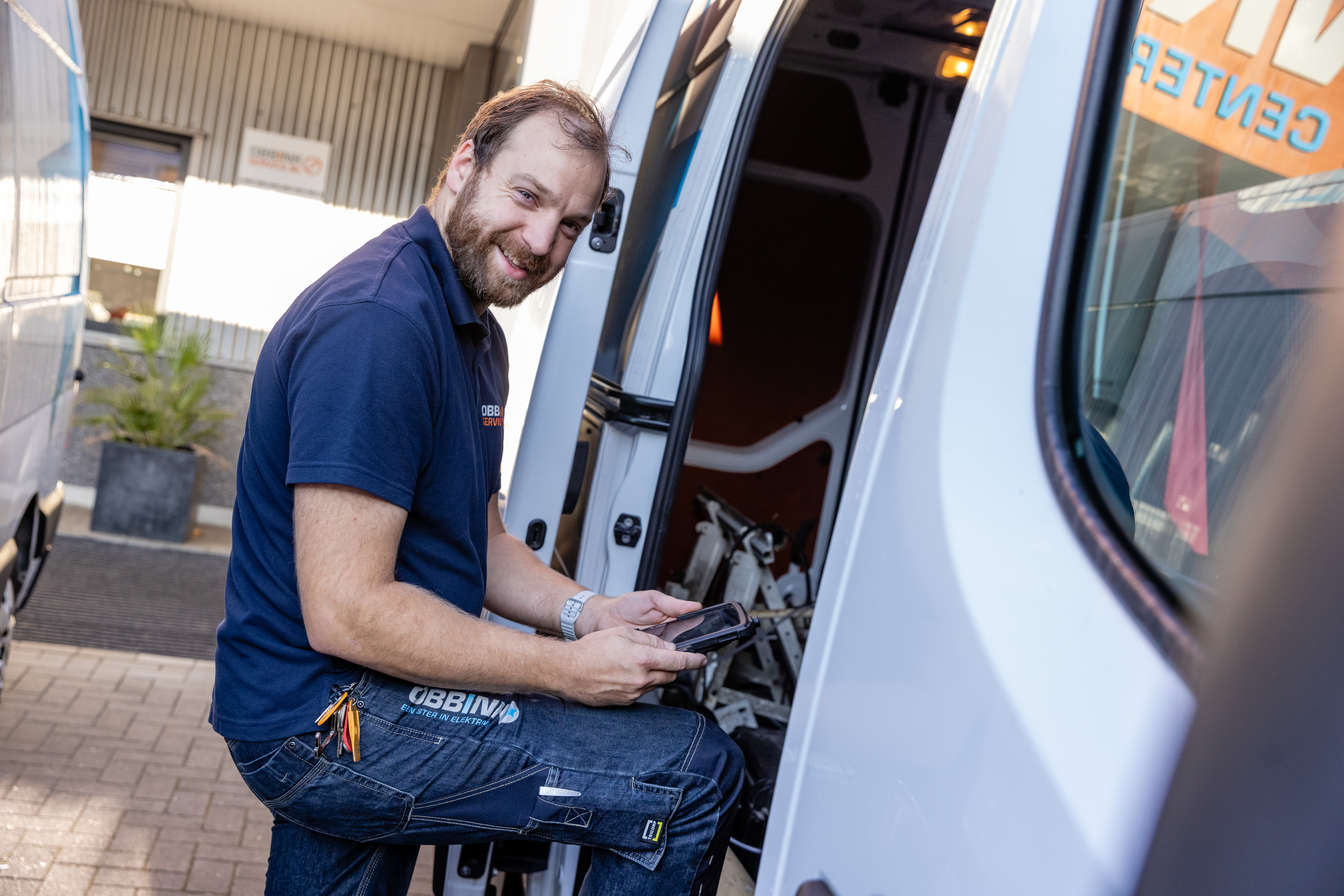 Obbink Service-monteur met tablet bij de geopende servicebus